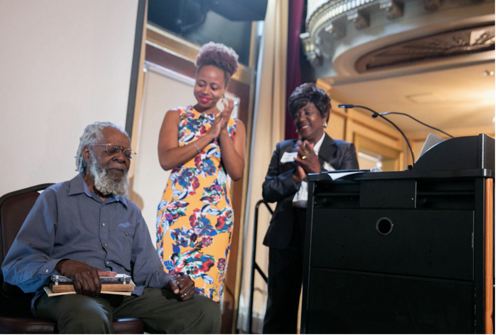 Clifford R. Joseph, age 96, receives the inaugural Cliff Joseph Award and honorarium given by the CPAT think tank in recognition of an educational career that has exemplified a radically transformative vision of the creative arts therapies that is committed to anti-racism, anti-imperialism, and dismantling interlocking forces of oppression. Leah Gipson and Anna Hiscox present the award on Saturday, September 15, 2018. Photo Credit: Zemaye Okediji